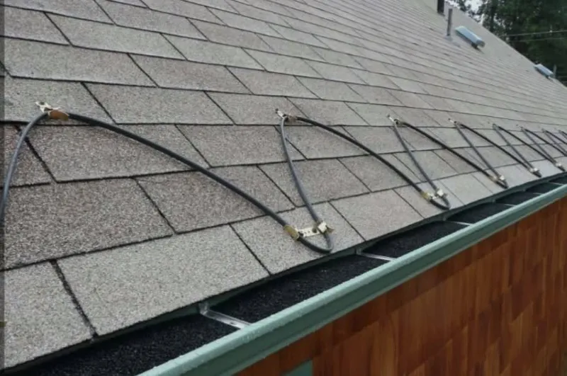 Heat cable run in a zigzag along a shingled roof edge above the gutter
